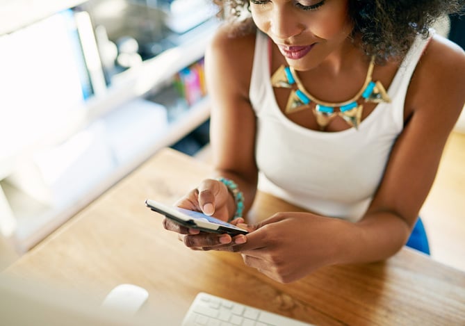 Empreendedora administrando seu negócio pelo celular com ferramentas de gestão