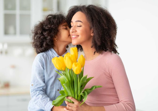 Uma criança beijando o rosto de uma mulher